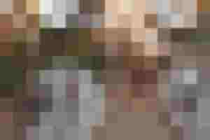 Tavola apparecchiata a festa con candele, piatti decorati e addobbi naturali per l'Avvento.