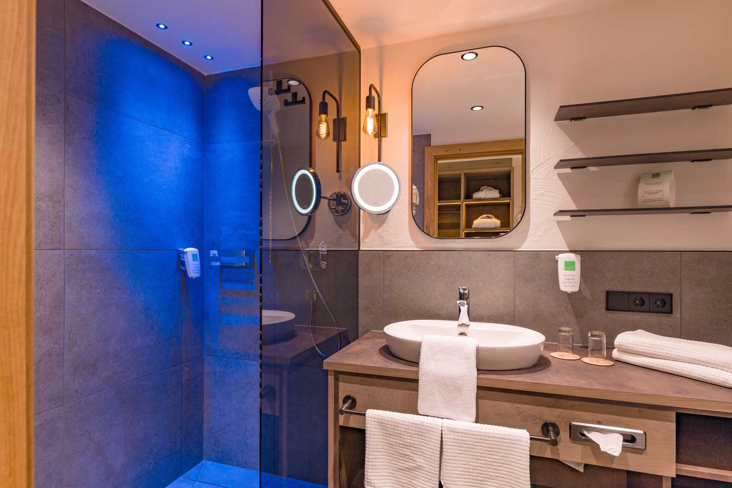 Modernes Badezimmer im Hotel Penzinghof mit Dusche, Waschbecken und eleganten Details.